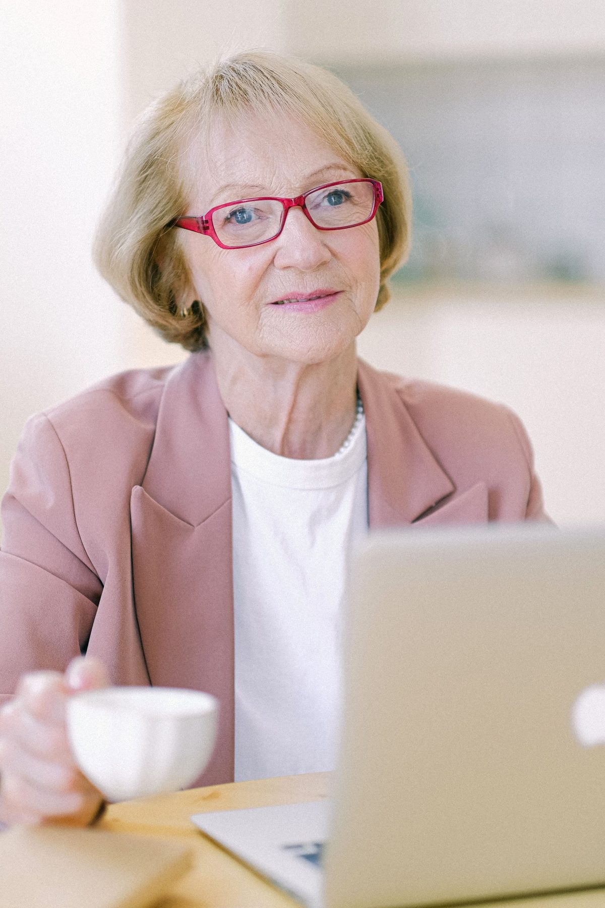 A woman working on her laptop at home with a cup of coffee