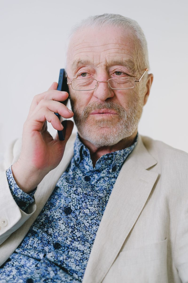 An older man taking a phone call