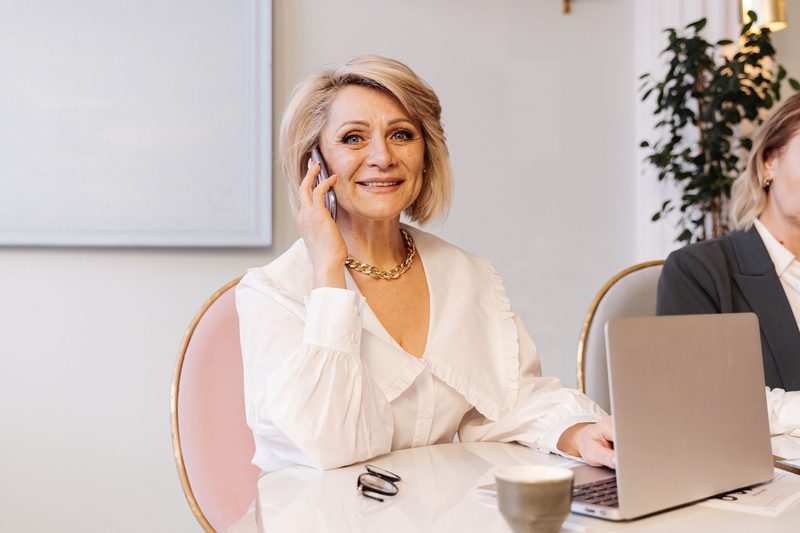A smiling businesswoman on the phone at her desk